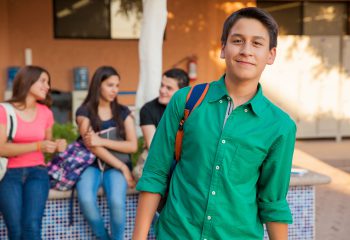 Portrait of an attractive teenage boy and his friends hanging out at school